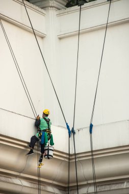 Yüksek bir binanın üzerinden cam temizleyici abseiling. 