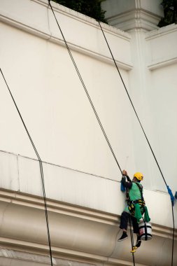 Yüksek bir binanın üzerinden cam temizleyici abseiling. 
