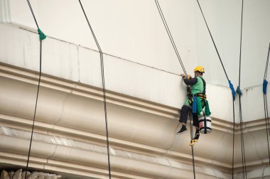Yüksek bir binanın üzerinden cam temizleyici abseiling. 