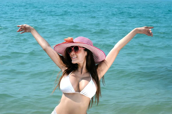Досить Азіатський жінка позує розслабитися на пляжі з рожевого капелюсі. — стокове фото