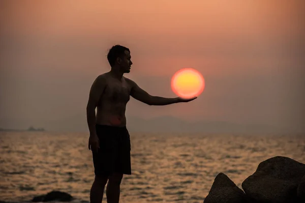 Männchen macht Fitness-Yoga und hält die Sonne an. — Stockfoto