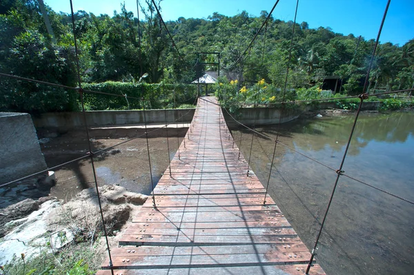 Puente colgante de alambre con camino de madera en Tailandia . —  Fotos de Stock