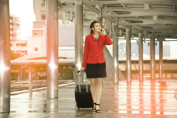 Asian pretty business woman standing with luggage and use smart phone. — Stock Photo, Image