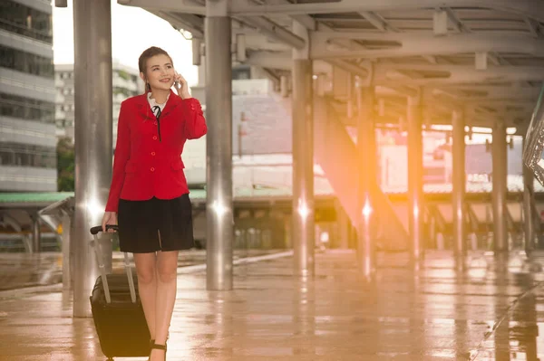 Asian pretty business woman standing with luggage and use smart phone. — Stock Photo, Image