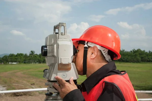 Surveyor nebo inženýra dělat opatření na poli. — Stock fotografie