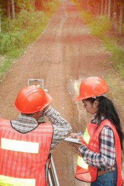 Arazi veya bir alandaki sokakta teodolit ölçü ile ortak yapım mühendisi. 
