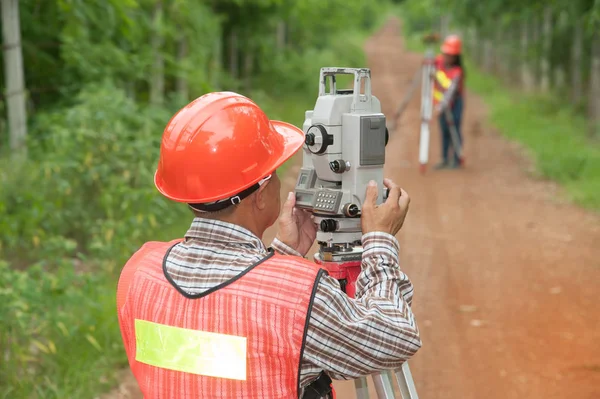 Arazi veya mühendis teodolit ve prizma reflektör ile ortak bir alanda ölçü yapma.