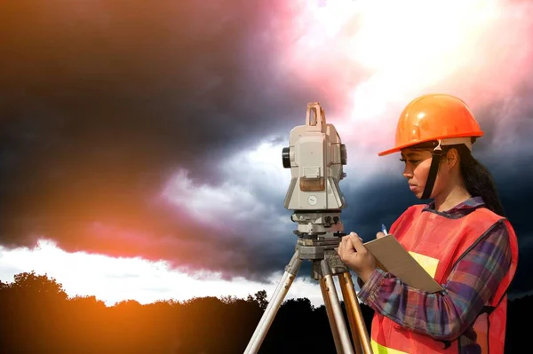 Vrouwelijke Surveyor of ingenieur maatregel door Theodoliet op het veld maken. — Stockfoto