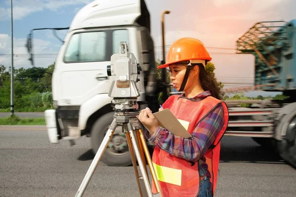 Vrouwelijke Surveyor of ingenieur maatregel door Theodoliet op de snelweg maken. — Stockfoto