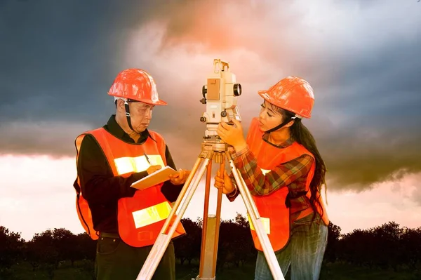 Földmérő, vagy mérnök, így intézkedés teodolit partner. — Stock Fotó