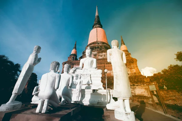 Ancient white buddha statues and ruined pagoda at Wat Yai Chai Mongkhon temple in Thailand.