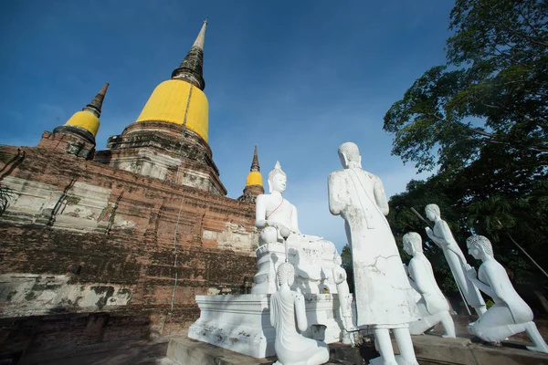 Ancient white buddha statues and ruined pagoda at Wat Yai Chai Mongkhon temple in Thailand.