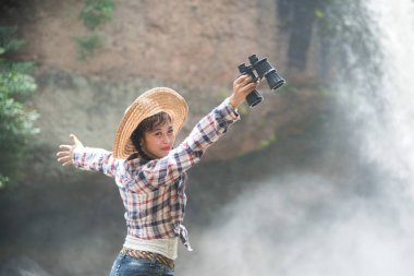 Bir dürbün mutluluk içinde tutan genç Asian traveler kadın.