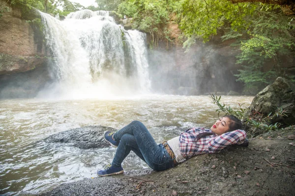 Mujer feliz acostada en una roca de cascada y libertad . — Foto de Stock