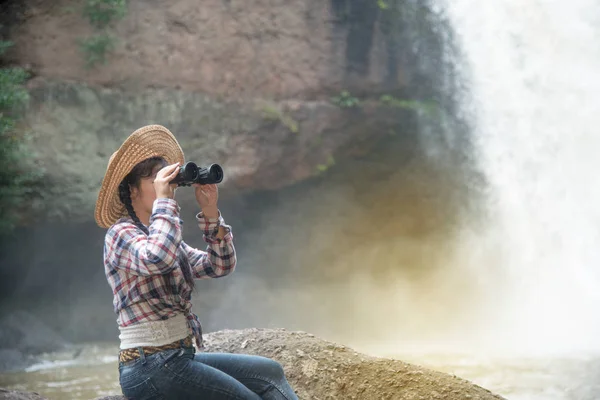 Unga asiatiska resenären kvinna som tittar en kikare i lycka. — Stockfoto