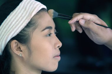 Güzel Asyalı kadın makyaj sanatçısı.