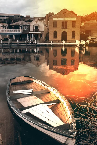 Ξύλινη βάρκα σε μια λίμνη και ιστορικό κτίριο. — Φωτογραφία Αρχείου