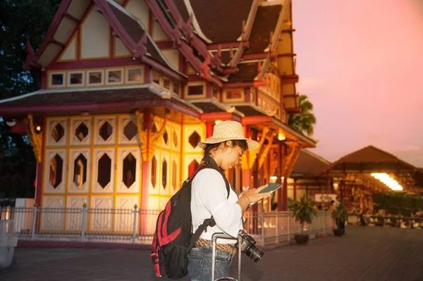 Красивая азиатская путешественница женщина ищет планшет и ждать поезд на железнодорожном вокзале в Таиланде . — стоковое фото
