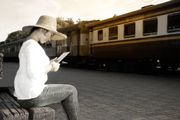 Θηλυκό Αρκετά Ασίας Ταξιδιώτης Κάθεται Κοιτάζοντας Tablet Και Περιμένουν Τρένο — Φωτογραφία Αρχείου