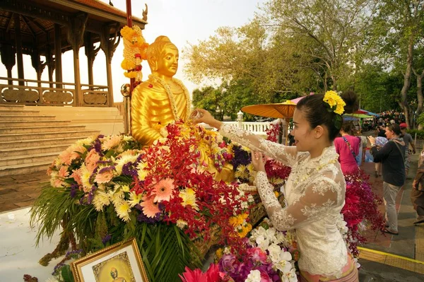 Frau besprengt Buddha-Bild beim Songkran-Fest mit duftendem Wasser. — Stockfoto