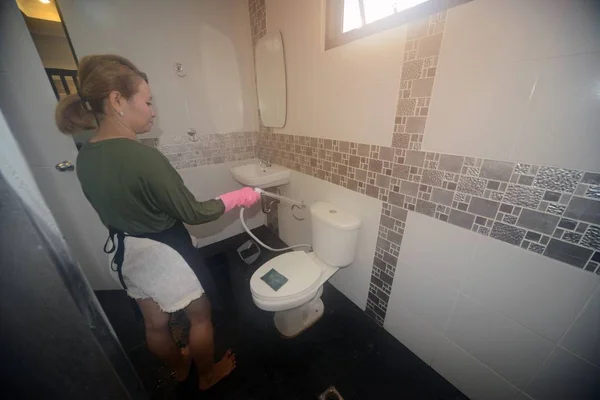 Asian female maid or housekeeper cleaning spray water closet. — Stock Photo, Image