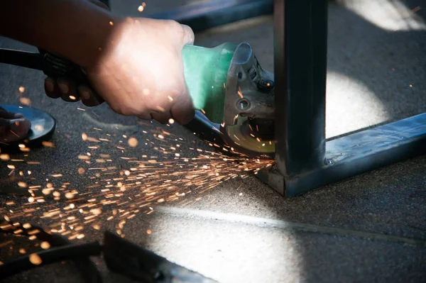 Працівник зварює металеву частину столової сталі на заводі . — стокове фото