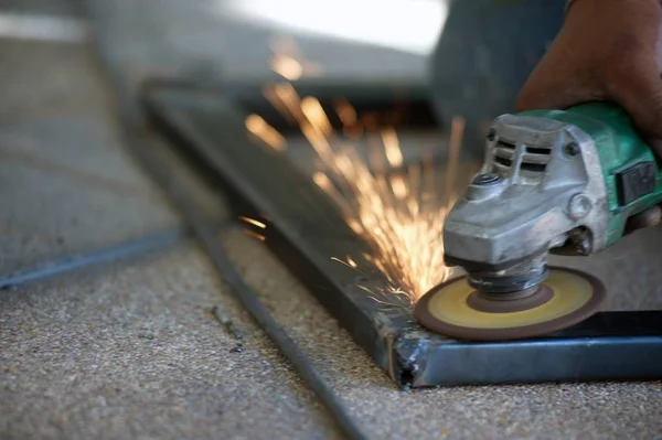 Pracownik jest spawanie metalowe części tabeli stali w fabryce. — Zdjęcie stockowe