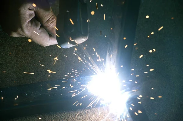 Працівник зварює іскри столової сталі на заводі . — стокове фото