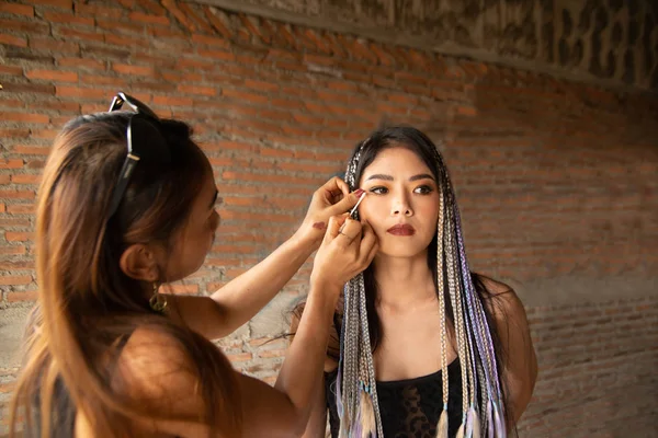 Maquiagem artista escrevendo olhos para uma mulher asiática . — Fotografia de Stock
