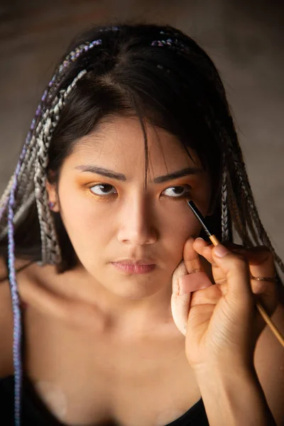 Makeup καλλιτέχνης γράφοντας τα μάτια για μια ασιατική γυναίκα. — Φωτογραφία Αρχείου