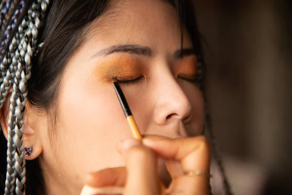 Makyaj sanatçısı Asyalı bir kadın için göz yazıyor.. — Stok fotoğraf