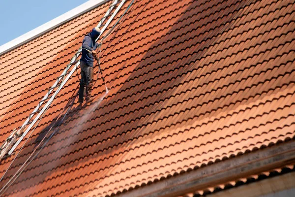 Telhado trabalhador superior com equipamento profissional Limpeza do telhado da casa com uma ferramenta de pressão . — Fotografia de Stock