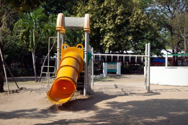 Halk parkındaki çocuk parkı aktiviteleri için bahçedeki çocuk parkı ekipmanları ve ağaç arka planı. 