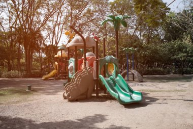 Halk parkındaki çocuk parkı aktiviteleri için bahçedeki çocuk parkı ekipmanları ve ağaç arka planı. 