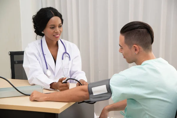 A female Doctor measuring male patient blood with pressure Measuring Patient.