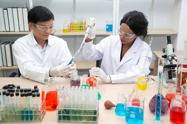 Twee wetenschappers werken in het laboratorium. Jonge vrouwelijke onderzoeker en haar senior toezichthouder doet onderzoek naar het laboratoriumapparatuur. — Stockfoto