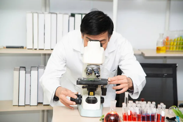 Científico usando microscopio en laboratorio. — Foto de Stock