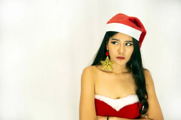 Una hermosa mujer asiática vestida con un traje de Santa muestra un estilo diferente. Con un fondo blanco como concepto para la celebración de Navidad . — Foto de Stock