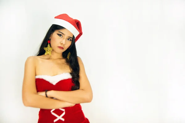 Uma bela mulher asiática vestida com roupa de Papai Noel mostra um estilo diferente. Com um fundo branco como um conceito para a celebração de Natal . — Fotografia de Stock