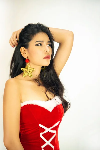 Una hermosa mujer asiática vestida con un traje de Santa muestra un estilo diferente. Con un fondo blanco como concepto para la celebración de Navidad . —  Fotos de Stock