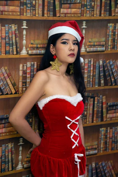 A beautiful Asian woman dressed in a Santa's outfit shows a different style as a concept for the Christmas celebration. — Stock Photo, Image