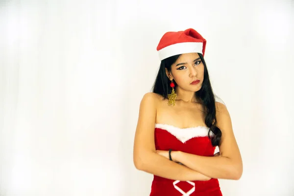 A beautiful Asian woman dressed in a Santa's outfit shows a different style. With a white background as a concept for the Christmas celebration. — Stock Photo, Image