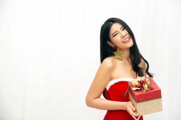 Una hermosa mujer asiática vestida con un hermoso Santa rojo. Mostrando gestos de alegría con una caja de regalo en aislado para las ideas de Navidad o Año Nuevo . —  Fotos de Stock