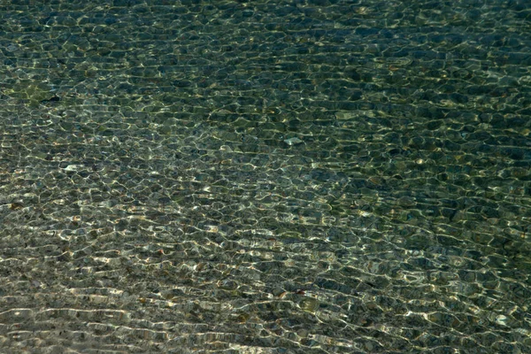 De achtergrond van het bovenaanzicht, helderblauwe zee. Het water is kristalhelder door het zonlicht dat schijnt. — Stockfoto