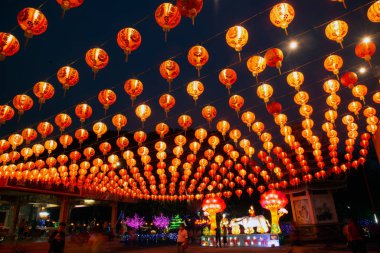 Red lanterns hanging in the black sky and god lamp at night in the Lantern Festival in Thailand.