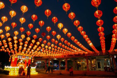 Red lanterns hanging in the black sky and god lamp at night in the Lantern Festival in Thailand.