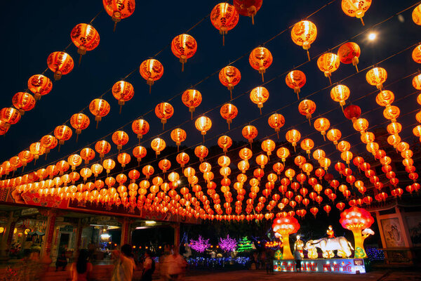 Red lanterns hanging in the black sky and god lamp at night in the Lantern Festival in Thailand.