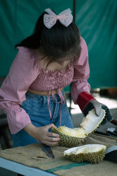 亚洲漂亮的女人用手撕裂榴莲 常被称为果皮之王 它是一种气味浓郁的大水果 是带有尖刺的坚硬外壳 — 图库照片