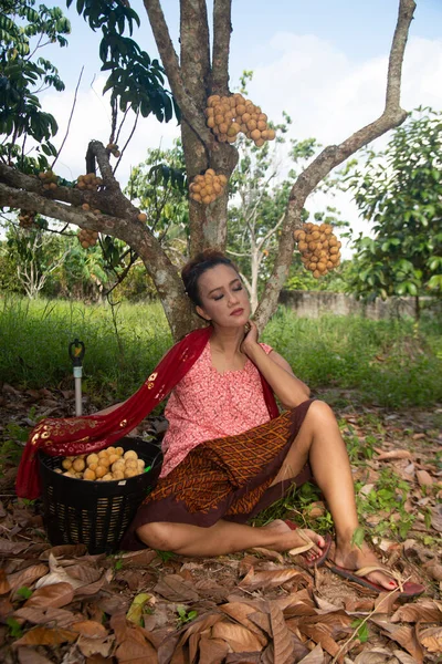 幸福と庭の竜の木の下でリラックスして座っているアジアの女性のポーズ — ストック写真