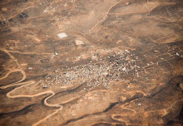 Photo from the plane with city view. Landscape with city in the desert.